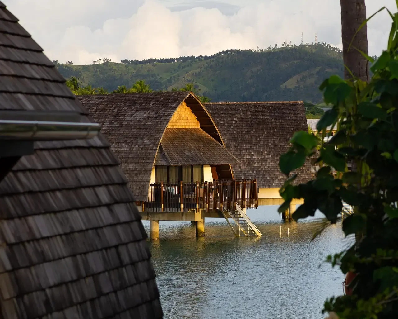 A thatched bungalow over the water at a resort in Fiji