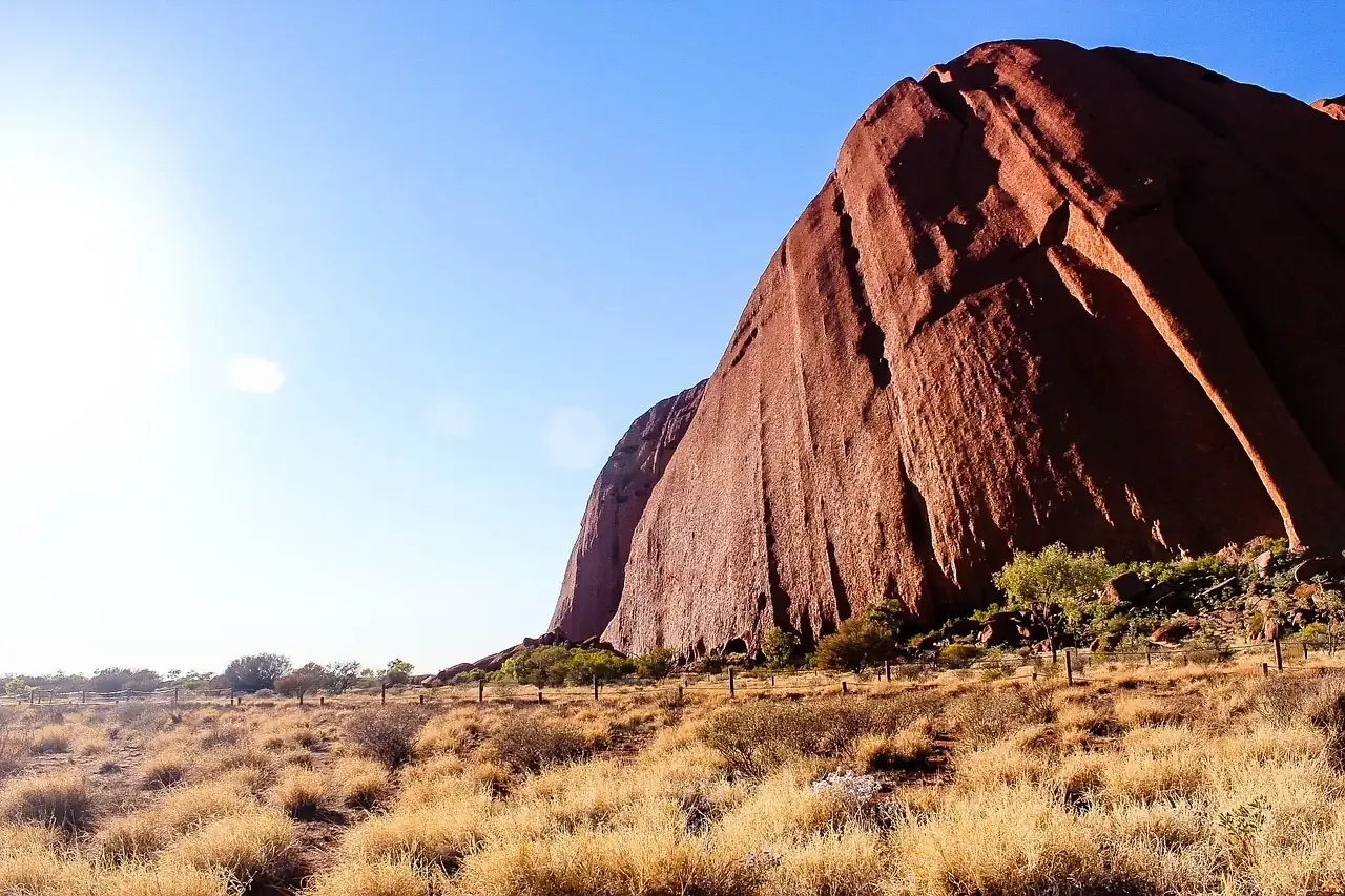 The ribbed and weathered flank of Uluru above the desert scrub