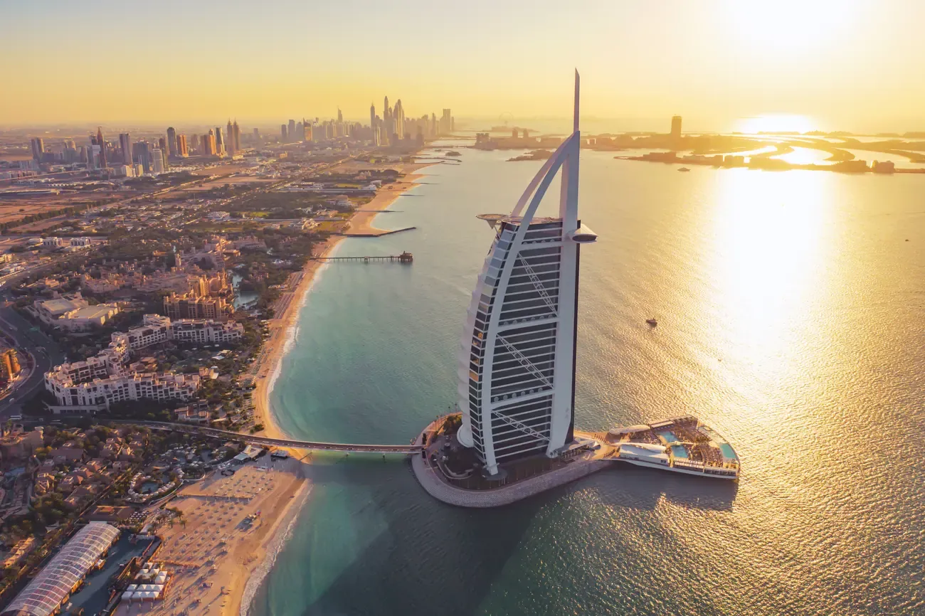 Aerial sunset view of the Burj Al Arab hotel along Jumeirah Beach.