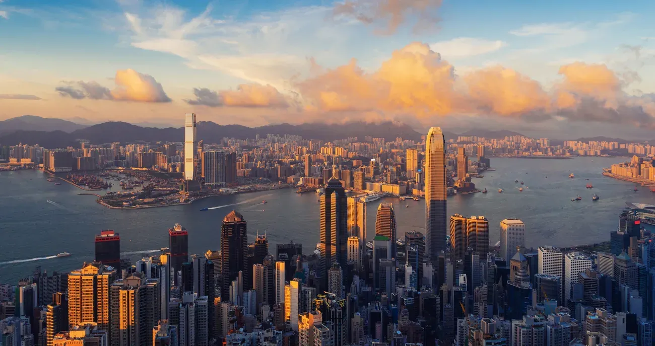 Victoria Harbour and the Hong Kong skyline at sunset.