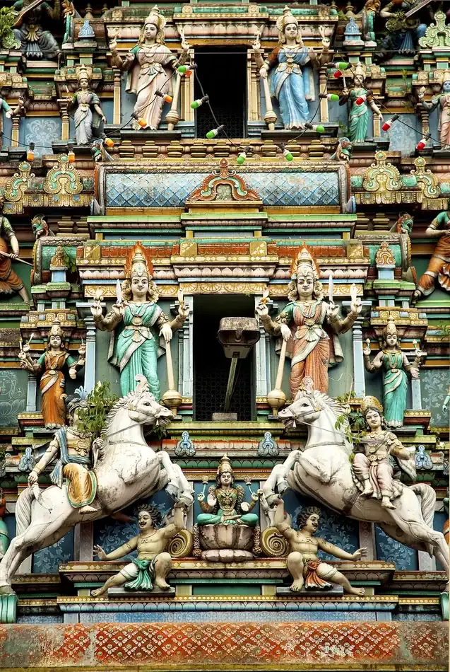 Colorful Hindu deity statues decorating a temple facade in Kuala Lumpur.