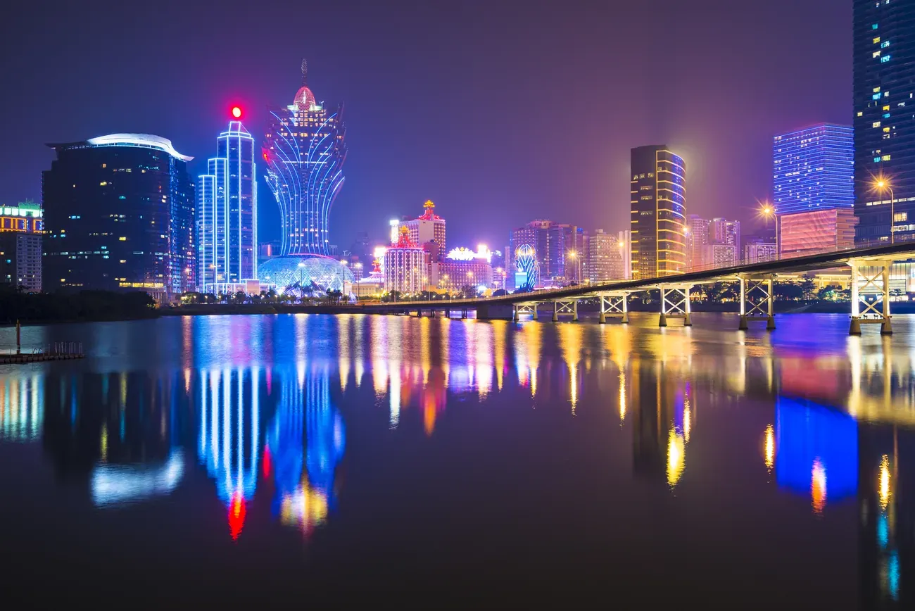 Macau's casino district skyline reflected in the water at night.