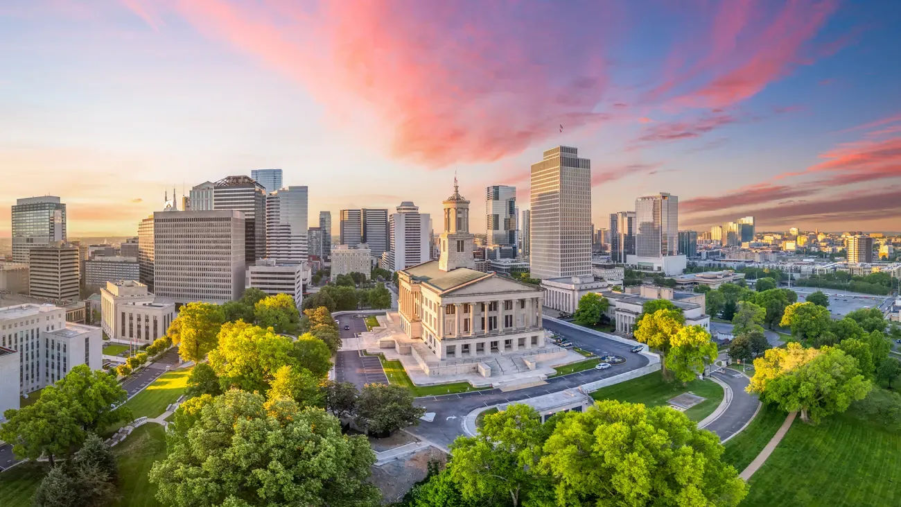 Tennessee State Capitol surrounded by the downtown Nashville skyline at dawn
