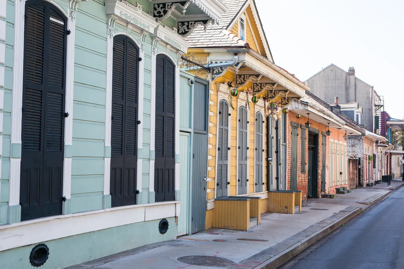 Row of pastel Creole cottages with shutters on a French Quarter street