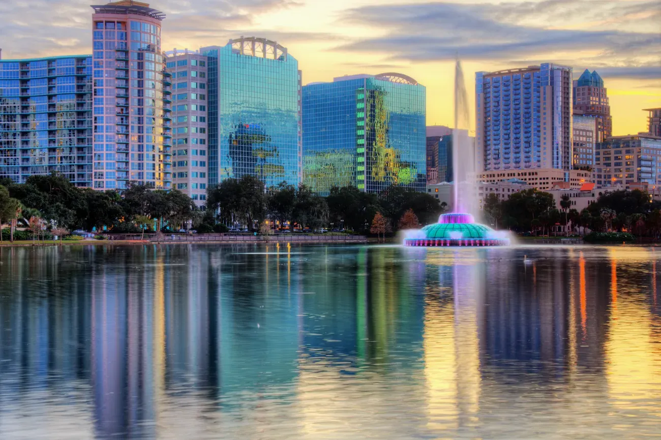 Lit fountain on Lake Eola with the Orlando skyline reflected behind it