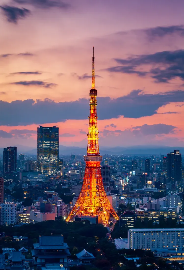 Tokyo Tower lit against a pink and purple sky at sunset