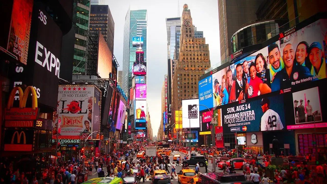 Crowds and illuminated screens filling Times Square at dusk in New York City