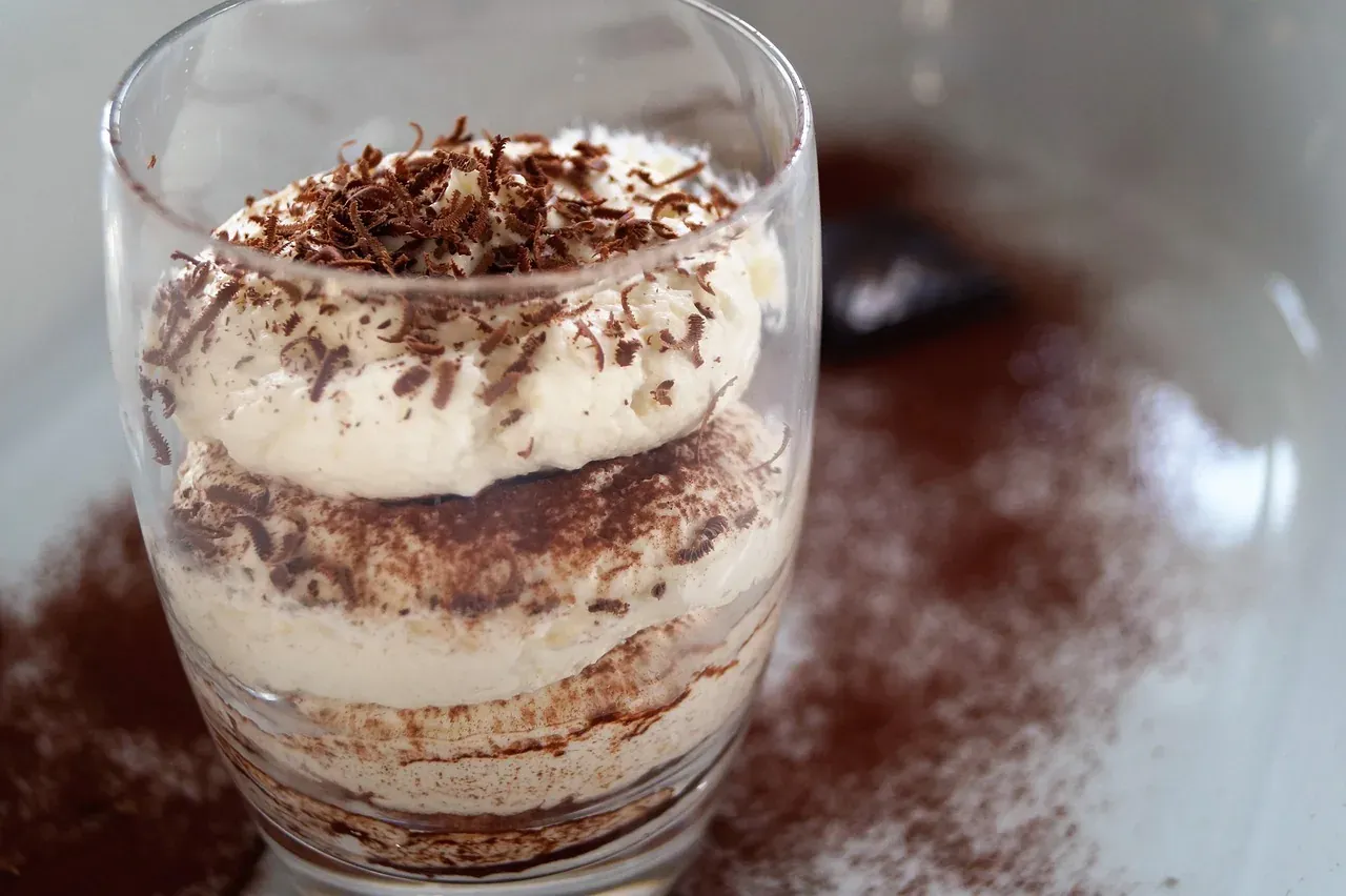 Tiramisu served in a glass with mascarpone layers and cocoa