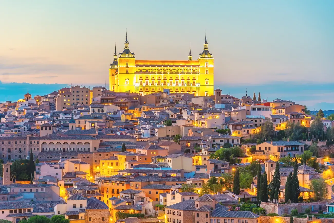 The illuminated Alcazar of Toledo overlooking the city at dusk, Spain
