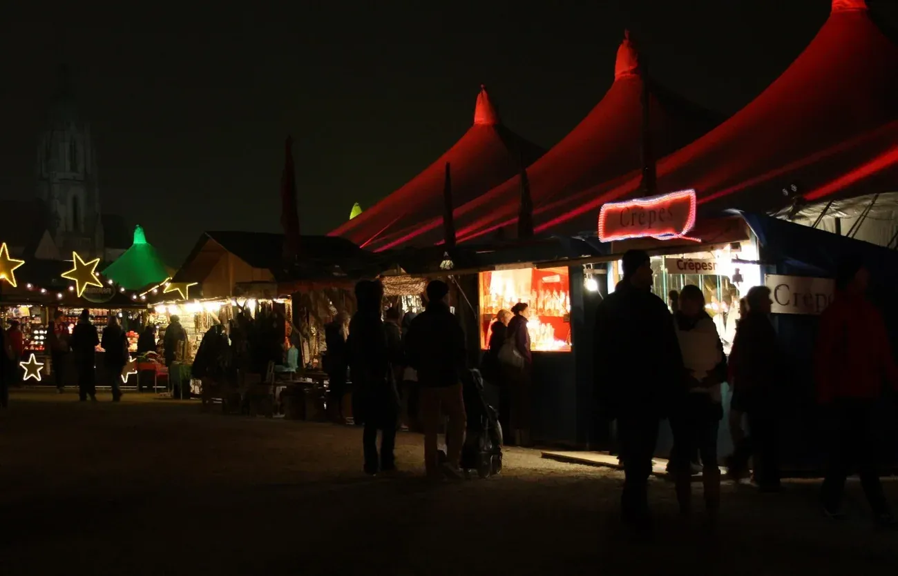 Red tents and stalls of the Tollwood Winter Festival on the Theresienwiese at night, Munich