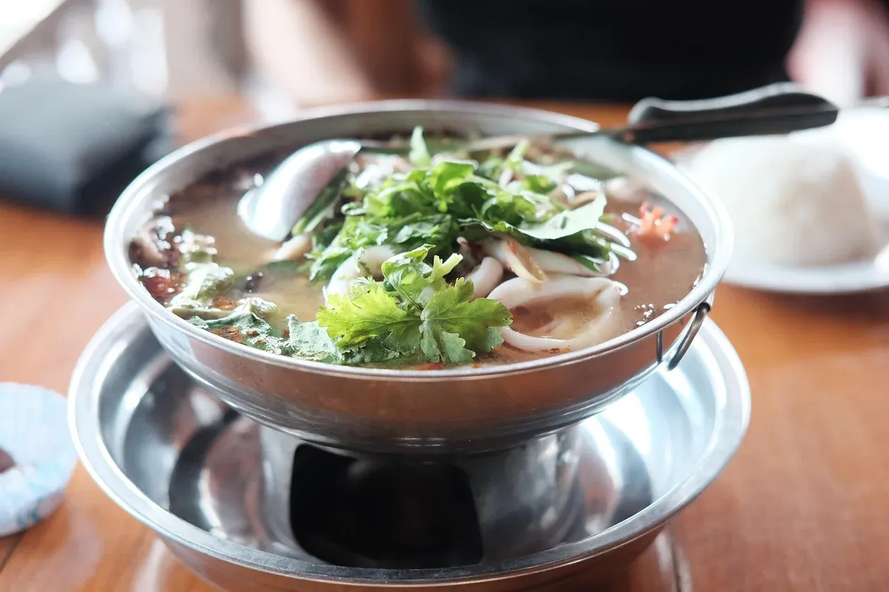 Tom yum kung served in a steel hot pot