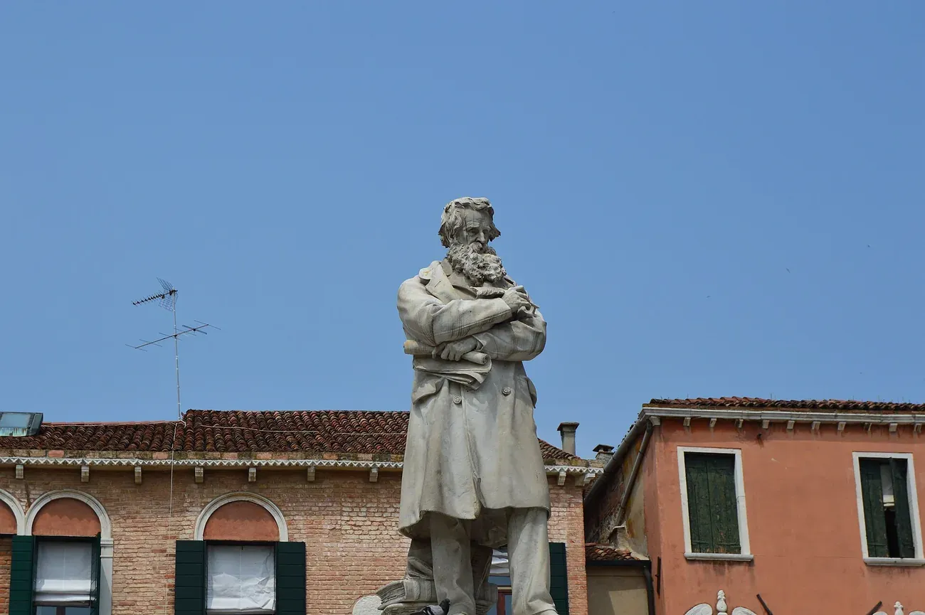 The statue of Niccolo Tommaseo standing on a pile of books in Campo Santo Stefano, Venice