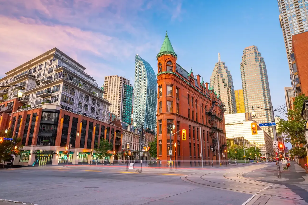The red-brick Gooderham flatiron building at dawn with the Toronto skyline behind