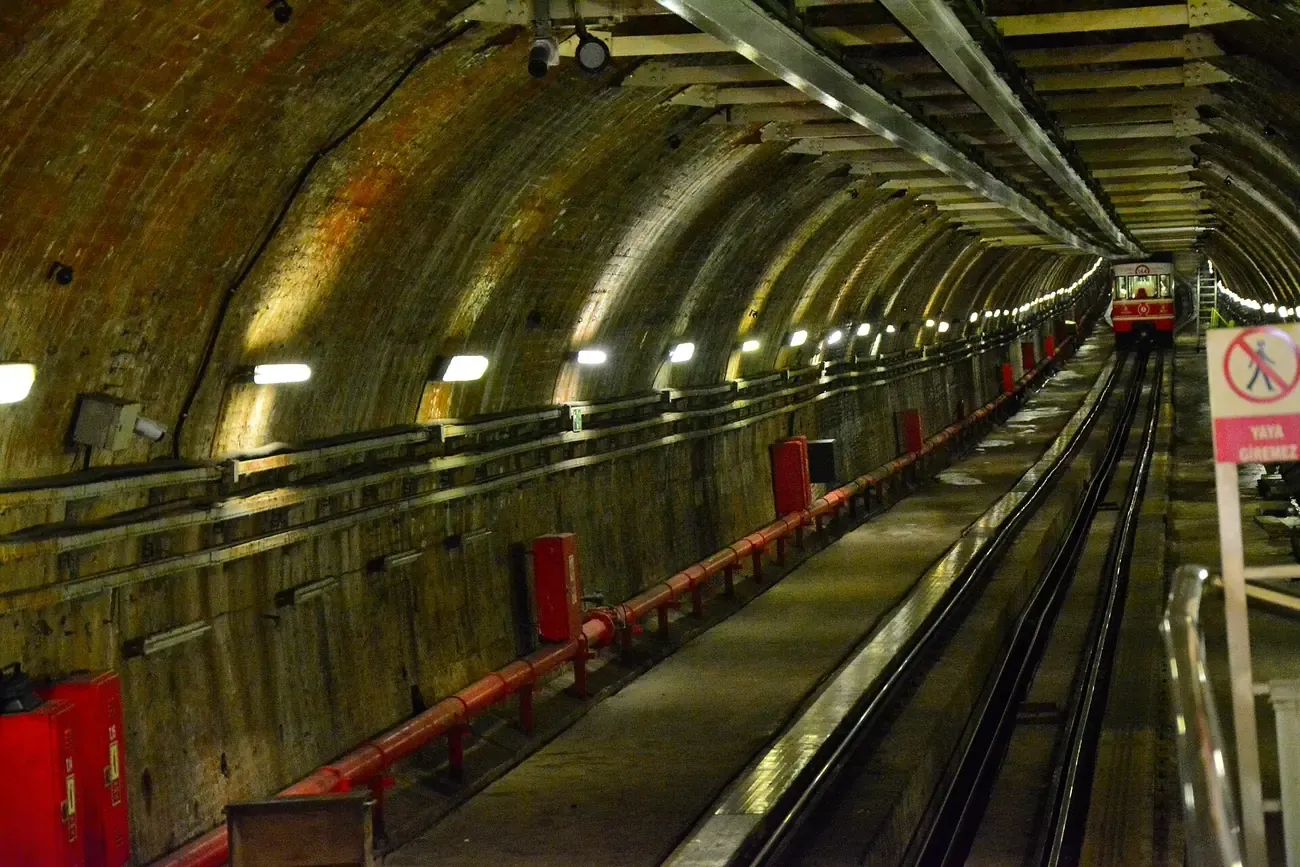 The brick-vaulted tunnel of the Tunel funicular between Karakoy and Beyoglu with a red car approaching, Istanbul