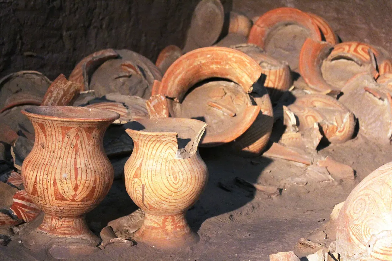 Red-painted burial pottery shown in the excavation display at Ban Chiang