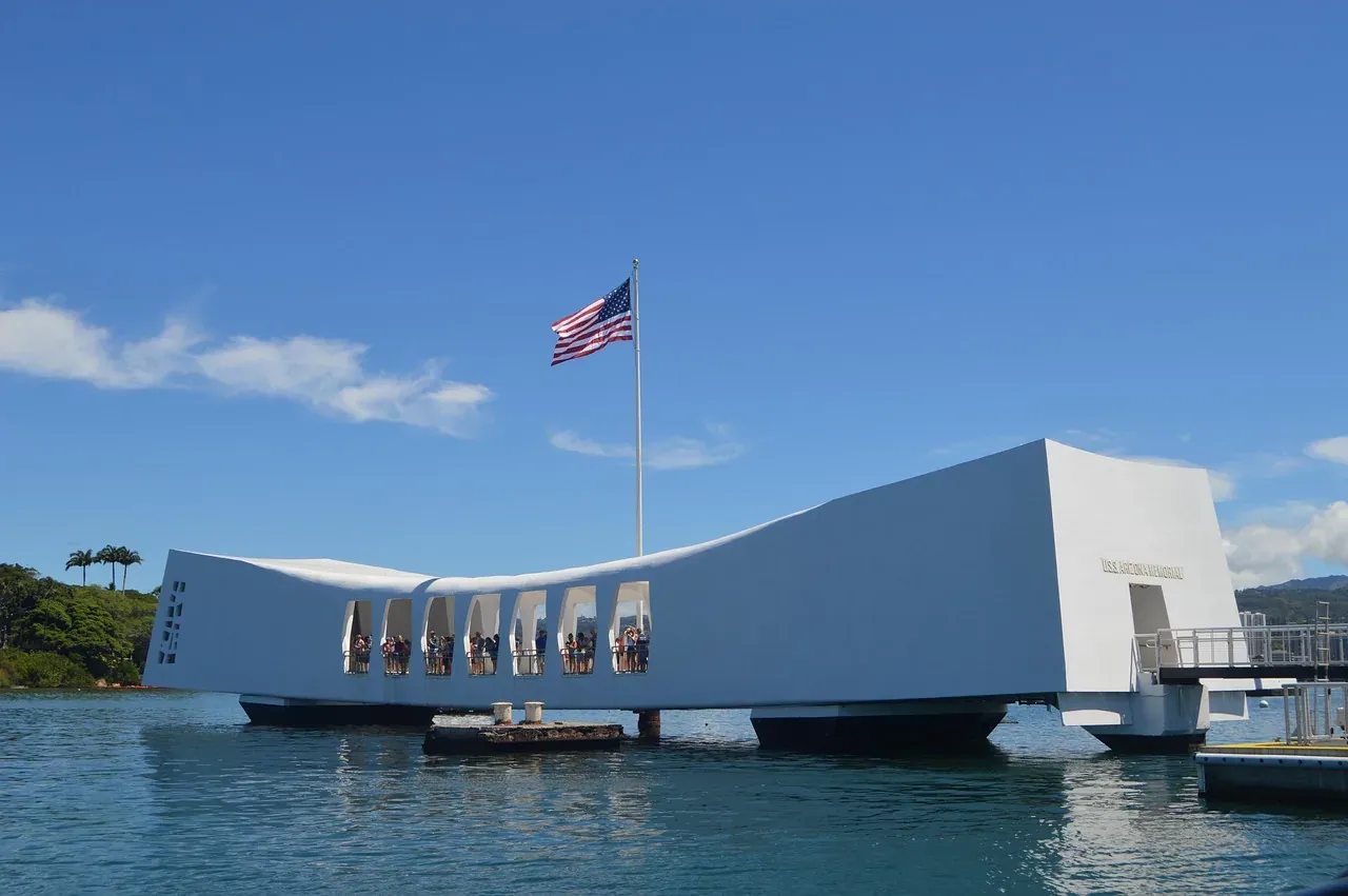 The white USS Arizona Memorial standing over the water at Pearl Harbor, Hawaii