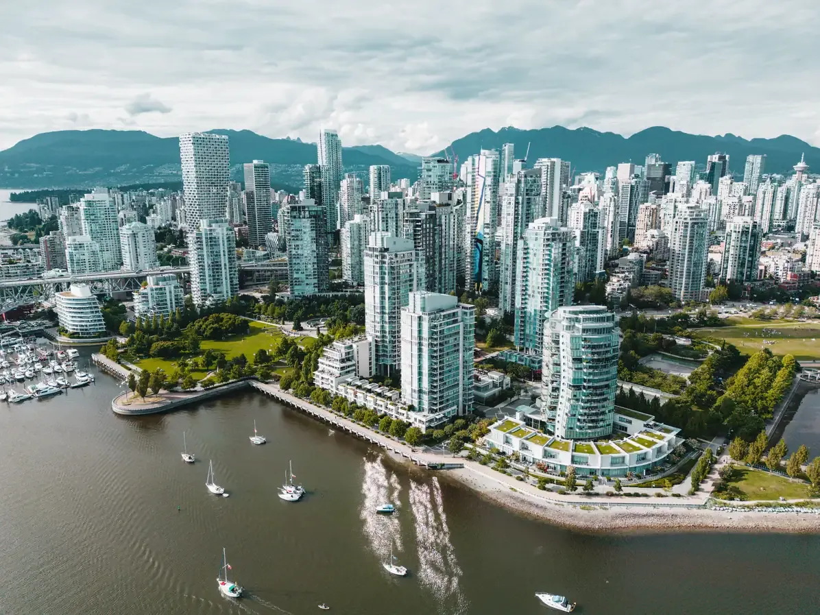 Aerial view of the glass towers, seawall and sailing boats on the Vancouver waterfront with the coastal mountains behind