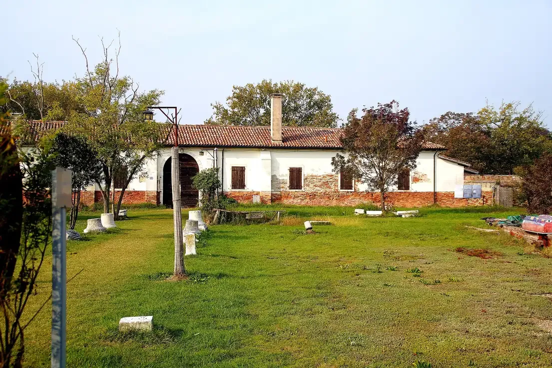 The whitewashed brick quarantine building and grassy grounds on the island of Lazzaretto Nuovo in the Venetian lagoon