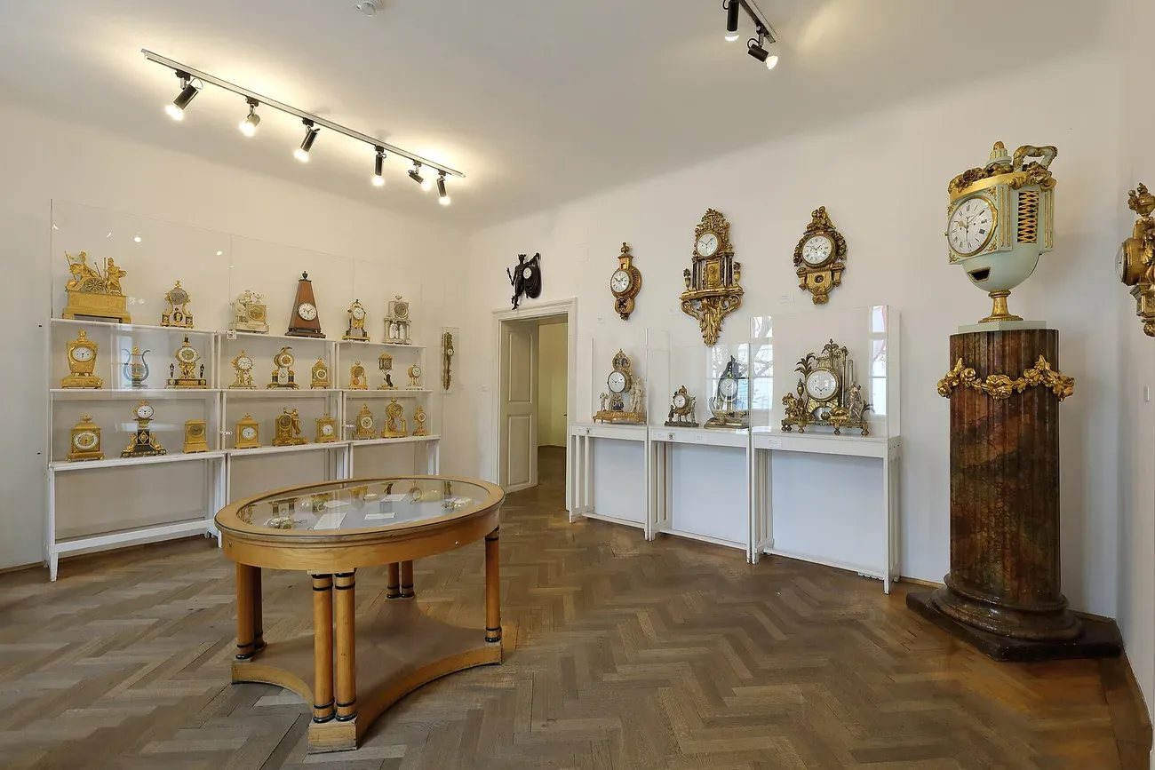 A gallery room at the Uhrenmuseum in Vienna lined with antique clocks and pocket watches in display cases