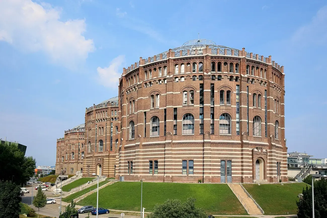 Two of the four converted brick gas holders of Gasometer Town rising over Simmering in Vienna