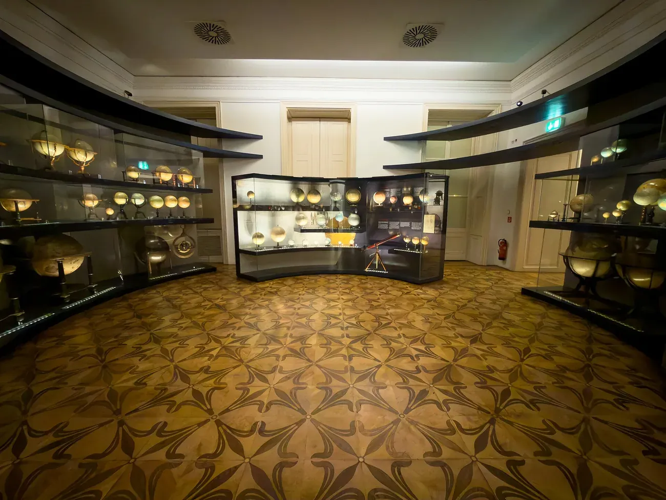 A gallery room at the Globe Museum in Vienna's Palais Mollard lined with illuminated antique globes