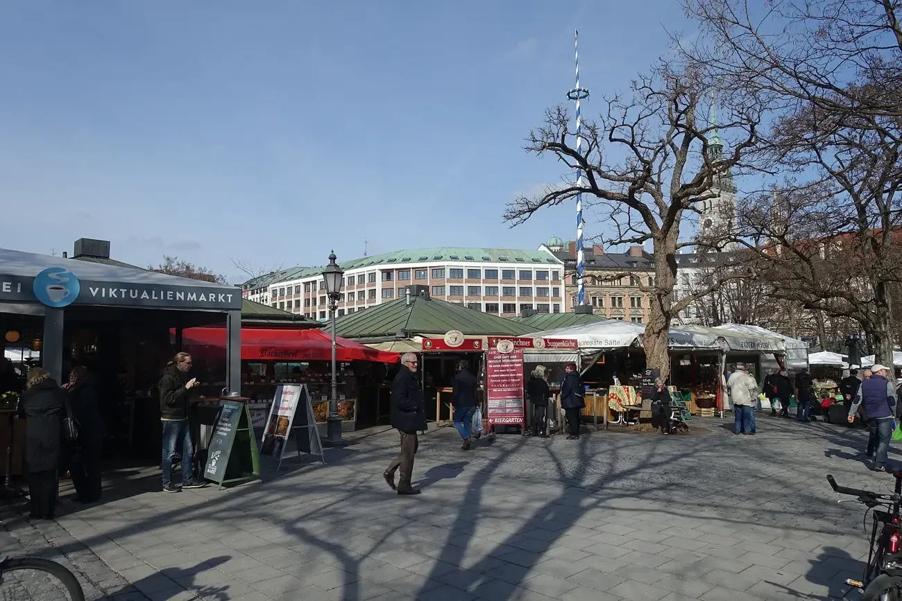 Stalls of the Viktualienmarkt with the tower of St Peter's church behind in Munich