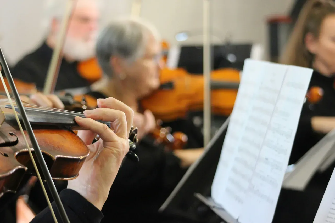 Musician playing violin next to a sheet music stand