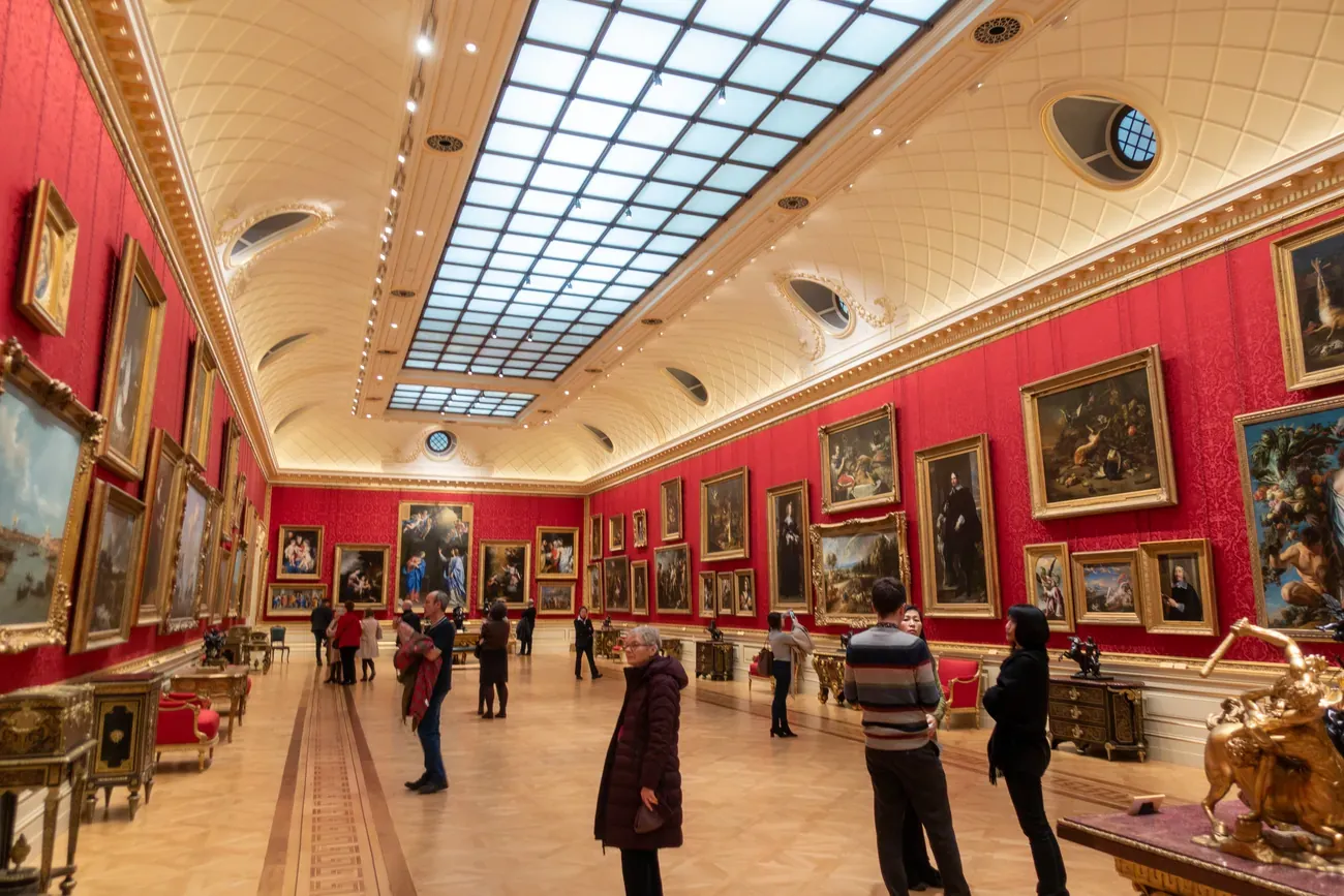 Visitors in the red-walled Great Gallery of the Wallace Collection in London