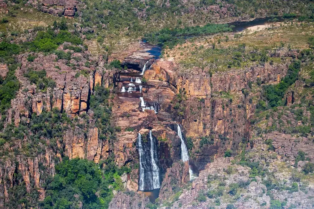 A waterfall dropping over the sandstone escarpment in Kakadu National Park