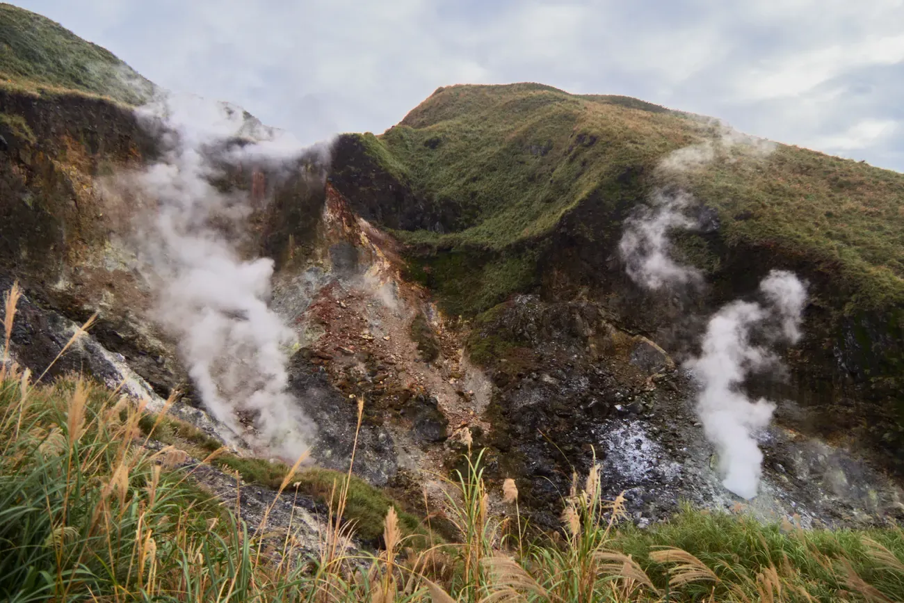 Steam rising from volcanic fumaroles on a hillside in Yangmingshan National Park near Taipei