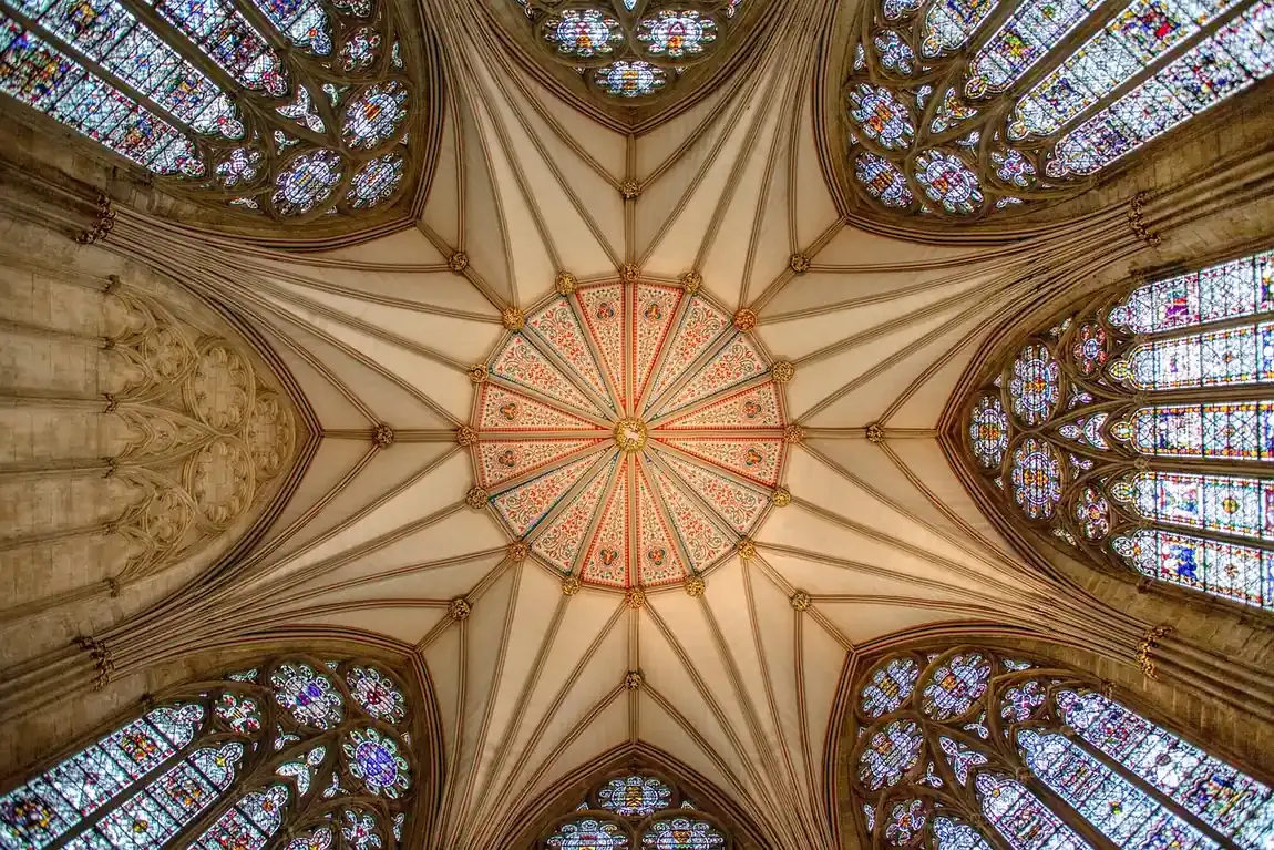 A vaulted ceiling ringed with stained glass windows inside York Minster in York