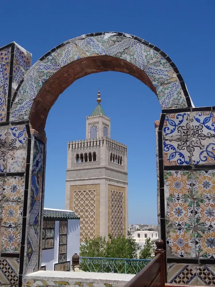 The minaret of the Zitouna Mosque framed by an arch in the medina of Tunis